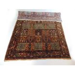 A handwoven Bakhtiari rug the triple line border surrounding the field with squares containing