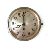 A German Third Reich type naval bulkhead clock, the silvered dial signed Junghans with red markers,