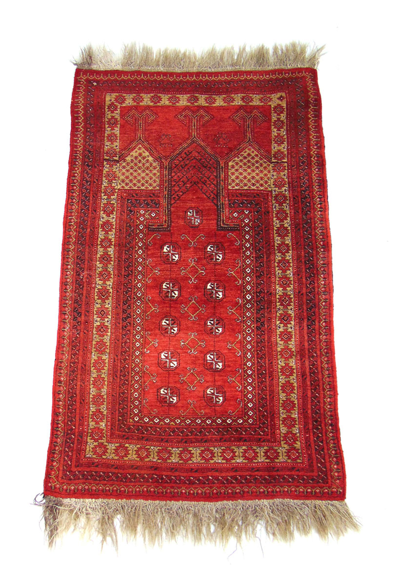 A handwoven Afghan prayer rug, the multi line border surrounding the red ground niche with octagons,