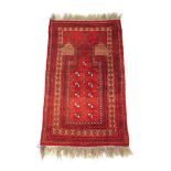 A handwoven Afghan prayer rug, the multi line border surrounding the red ground niche with octagons,