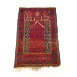 A handwoven Turkish prayer rug, the triple line border enclosing the red ground niche,