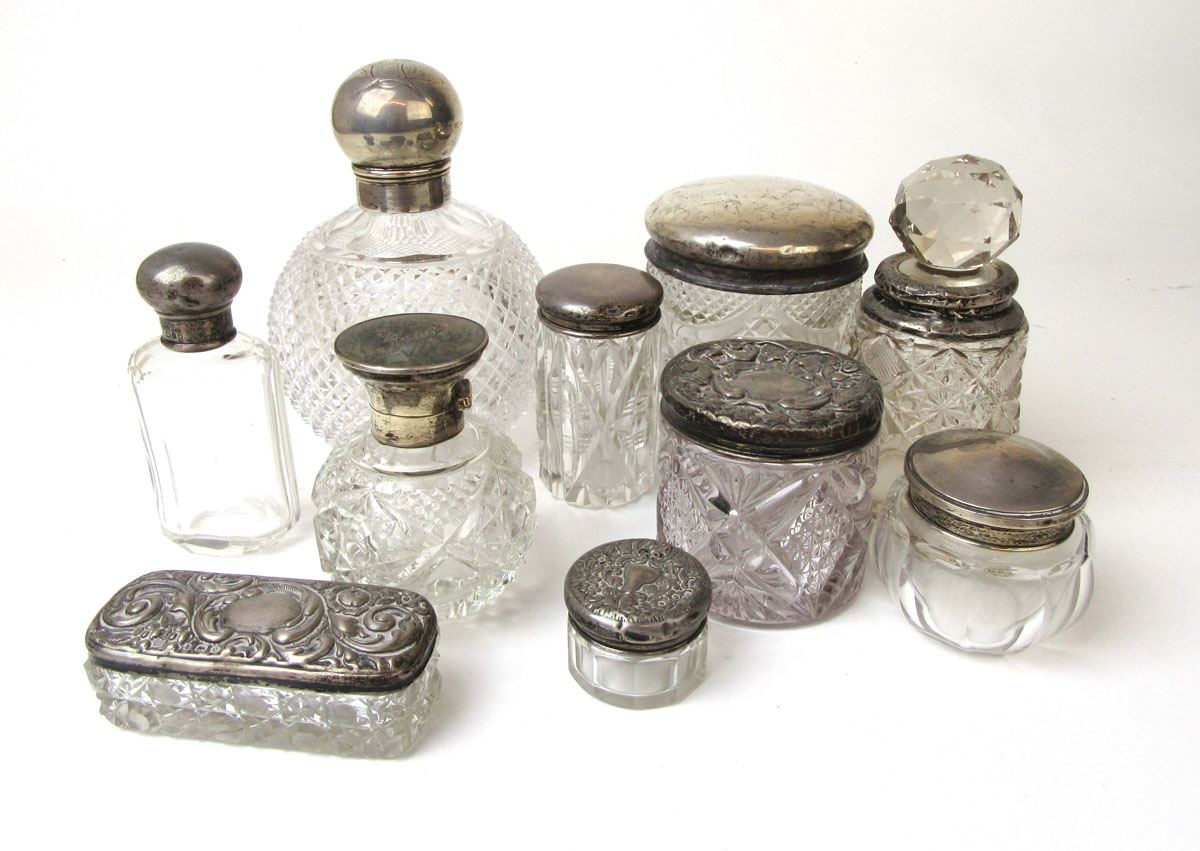 A collection of ten silver topped and cut glass bottles/containers to include a globular example.