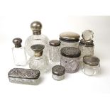 A collection of ten silver topped and cut glass bottles/containers to include a globular example.