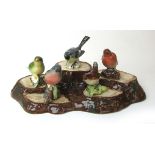 A Beswick tree stump stand together with a selection of Besick models of birds comprising of