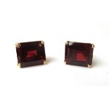 A pair of 14ct yellow gold screw-type earrings each set with a baguette cut red coloured stone.