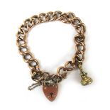 A Victorian 9ct rose gold bracelet having a padlock clasp and suspending a small yellow metal seal