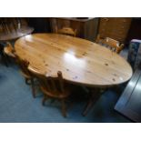 A modern pine oval dinning table together with a set of four matching chairs