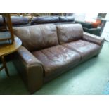 A tan leather substantial three seater settee