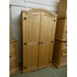 A modern pine two door arch topped wardrobe
