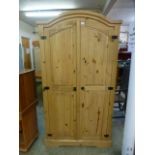 A pine two door arch topped wardrobe