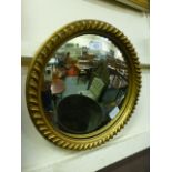 A circular gilt framed convex wall mirror