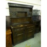 A mid 20th century dark oak dresser having raised back with leaded doors,