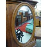 An early 20th century oak bevel glass oval mirror