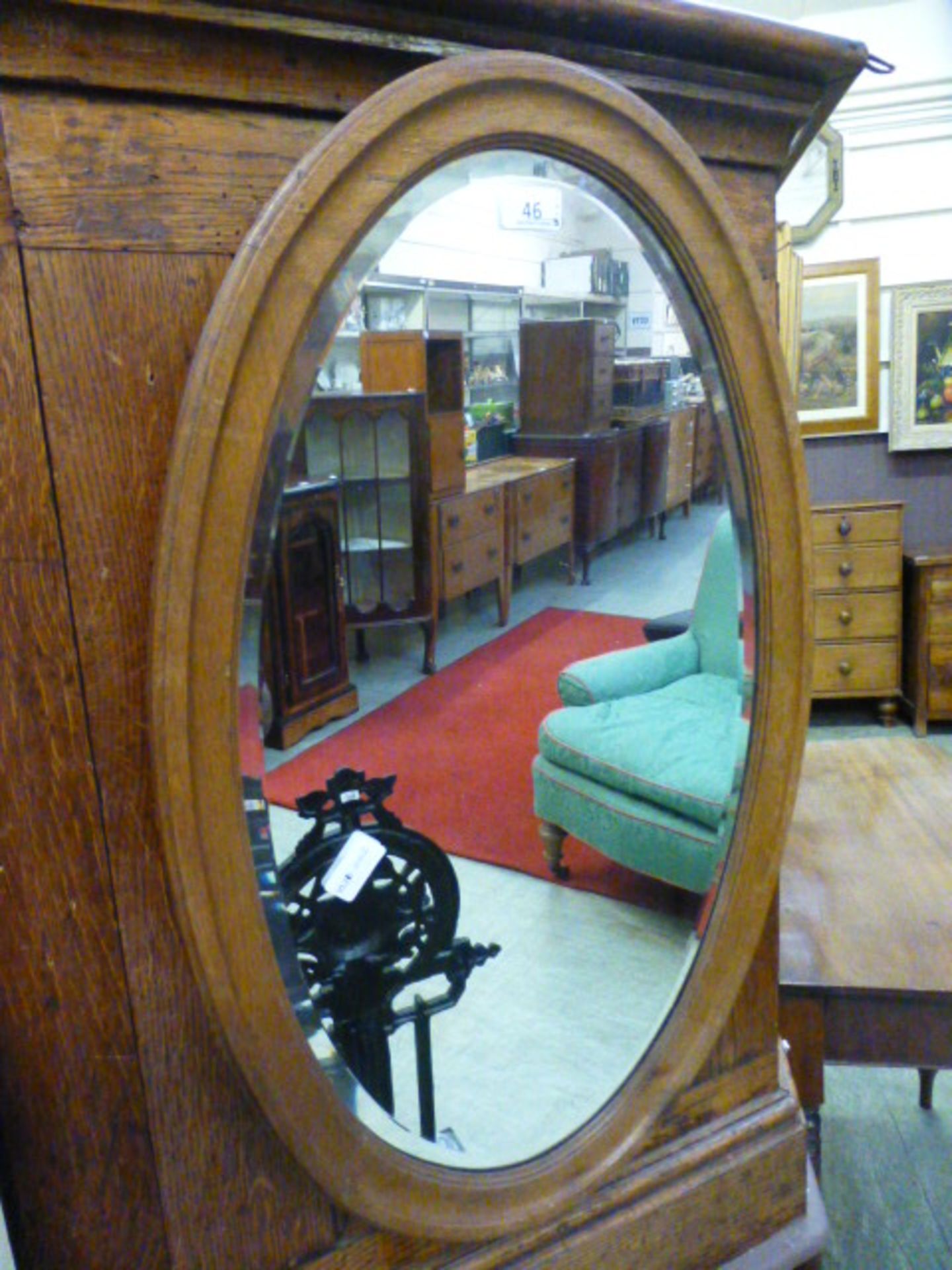 An early 20th century oak bevel glass oval mirror