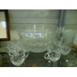 A cut glass punch bowl with matching mugs