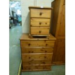 A modern pine chest of five long drawers along with a bedside chest of three drawers