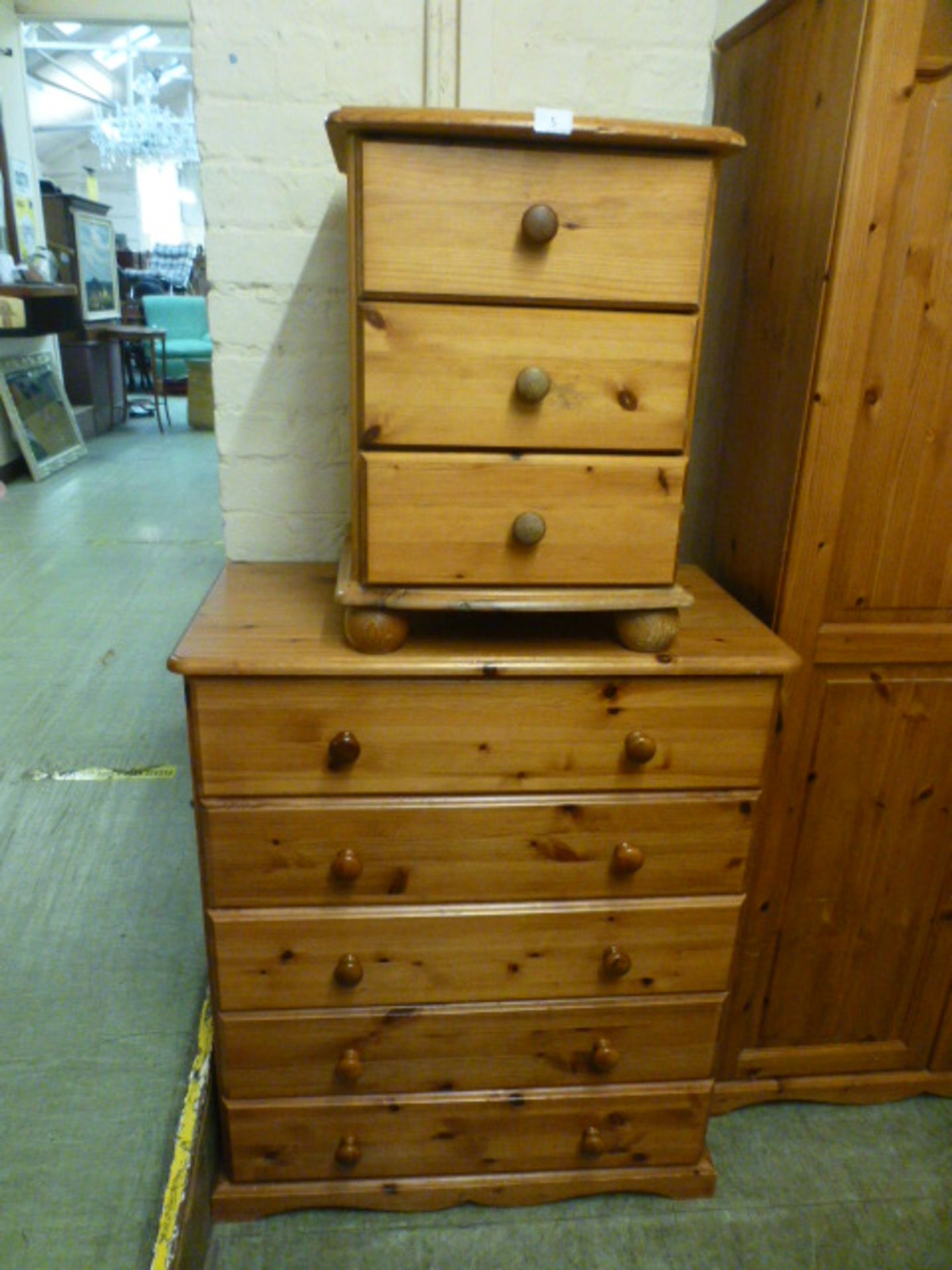 A modern pine chest of five long drawers along with a bedside chest of three drawers