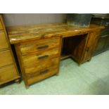 An Indonesian hardwood desk having a bank of three drawers with cupboard door