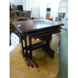 A nest of three cherry wood effect occasional tables