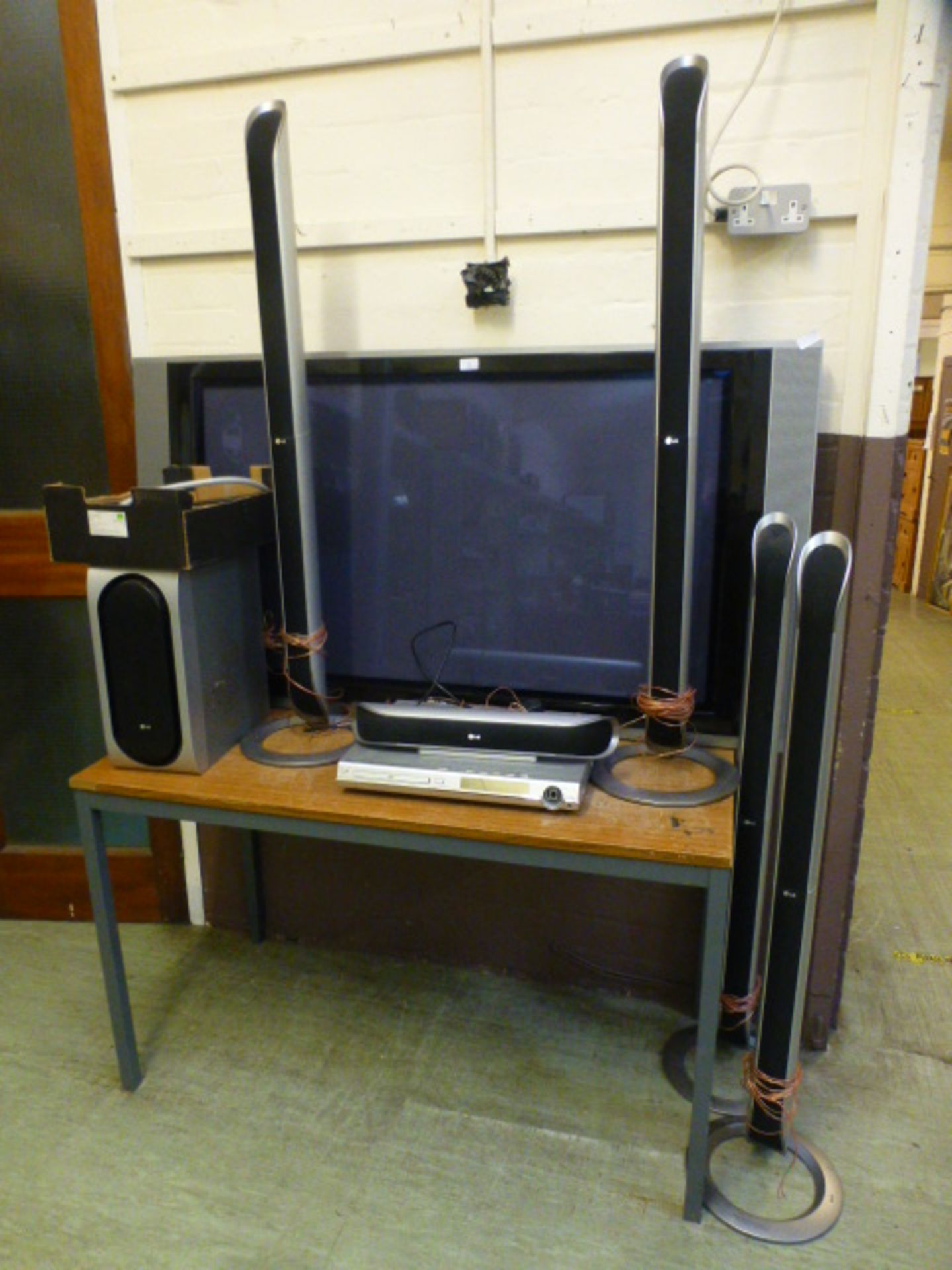 An LG flat screen TV along with a LG DVD player, surround sound speakers etc.