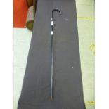 A silver collared and tipped ebonized walking stick