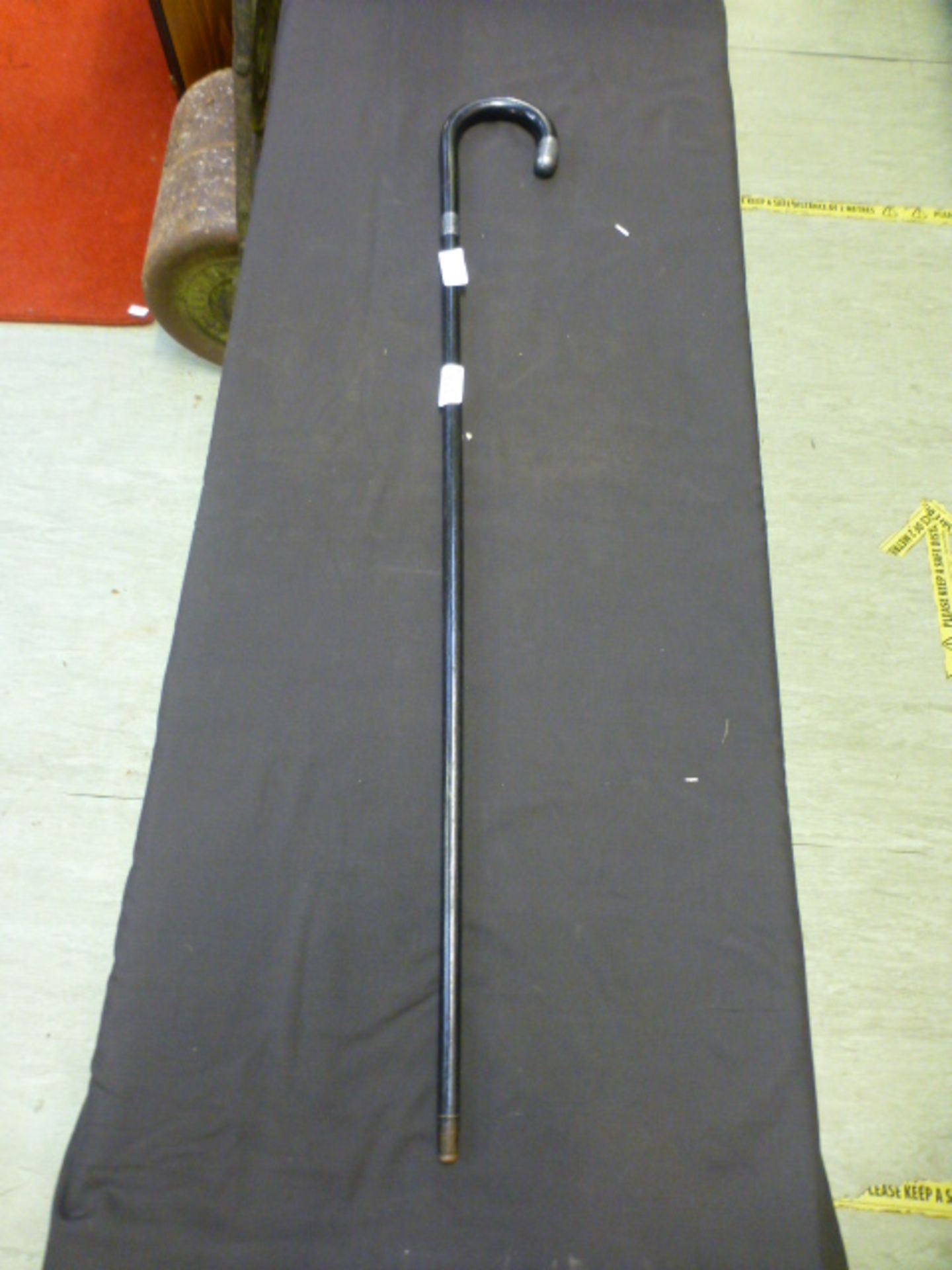 A silver collared and tipped ebonized walking stick