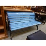 A blue painted wooden garden bench with cast metal end supports