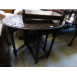An early 20th century carved oak topped gate leg table with barley twist supports