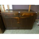 A mid 20th century oak sideboard with two drawers over two cupboard doors