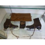 A pair of early 20th century brown leather ice skates together with a leather purse,