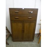 A mid 20th century oak cabinet with two drawers over two cupboard doors