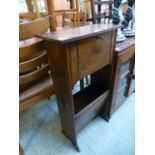 An early 20th century oak cabinet with pull down front and newspaper rack below