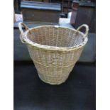 A wicker twin handled log basket