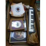 A tray containing 45 rpm records, prints, Melodica piano no.