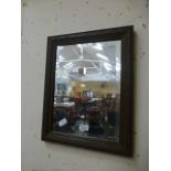 A carved framed bevelled glass rectangular mirror