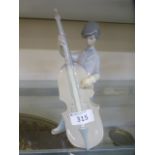 A Lladro model of a young boy playing the cello