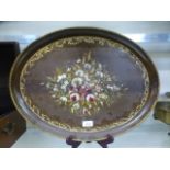 A papier mache oval tray with floral decoration