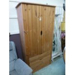 A modern pine two door wardrobe with three drawers to base