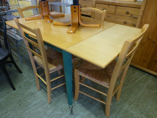 A modern beech extending kitchen table along with a set of four rush seated chairs