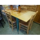 A modern beech extending kitchen table along with a set of four rush seated chairs