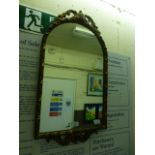 An ornate gilt framed arch top mirror