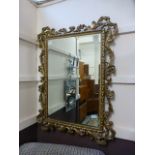 A reproduction ornate gilt framed bevelled glass wall mirror