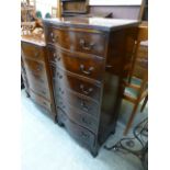 A reproduction mahogany serpentine fronted chest of six drawers