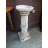 A composite stone pedestal with figures to column