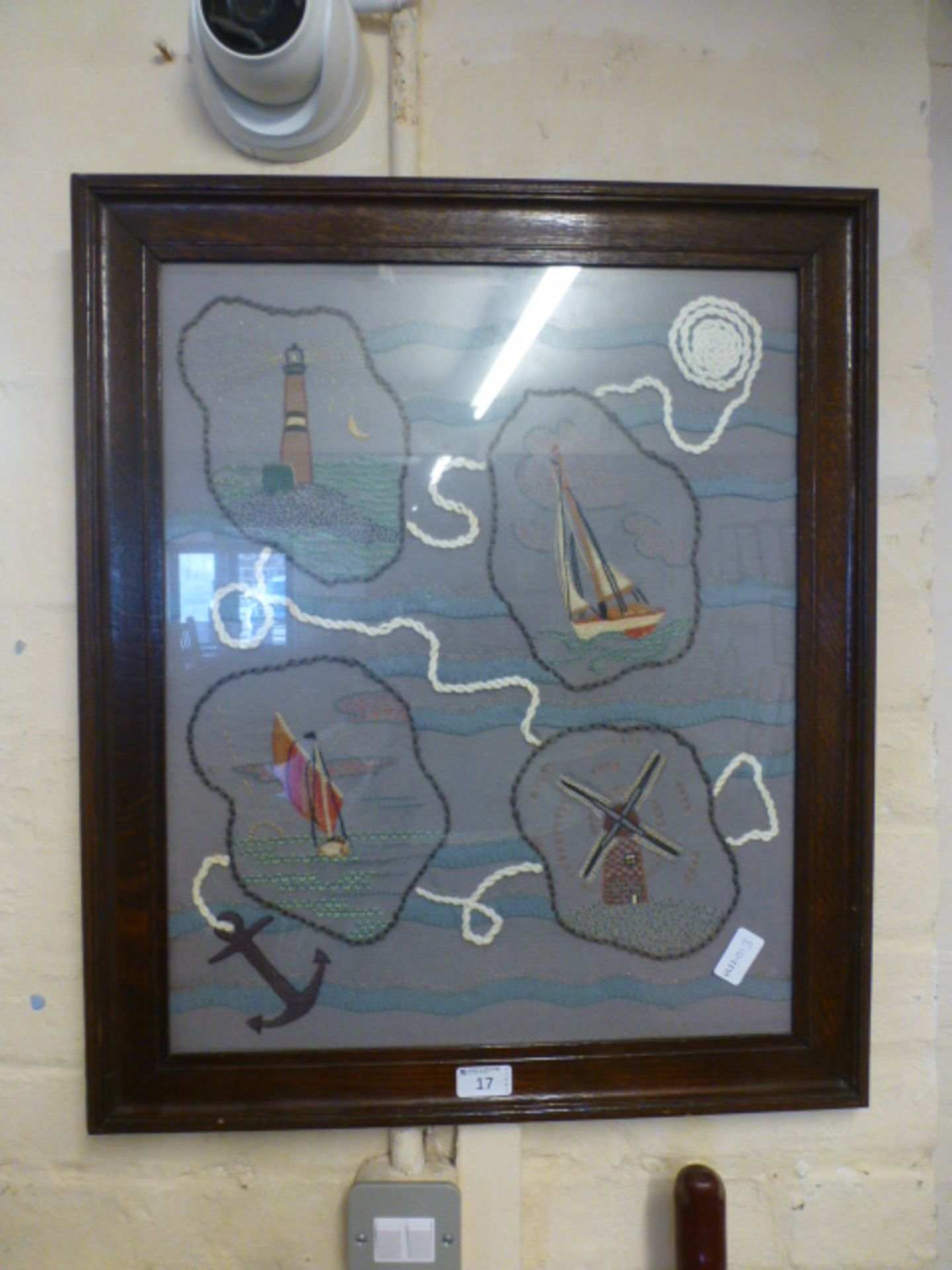 A framed and glazed needlework on a nautical theme