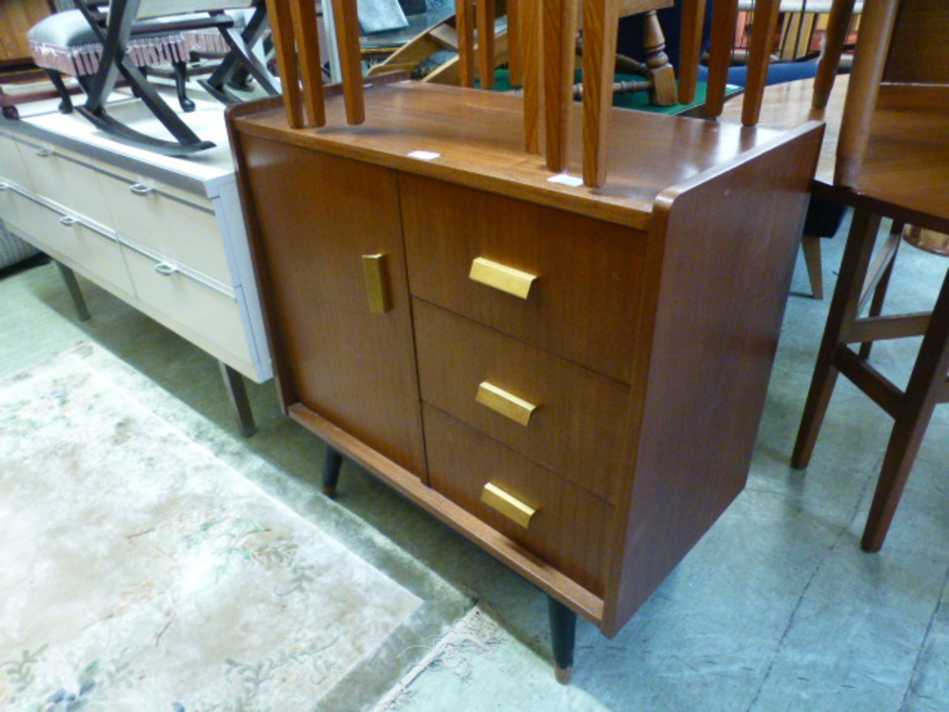 A mid-20th century design teak cabinet having three drawers with single door CONDITION