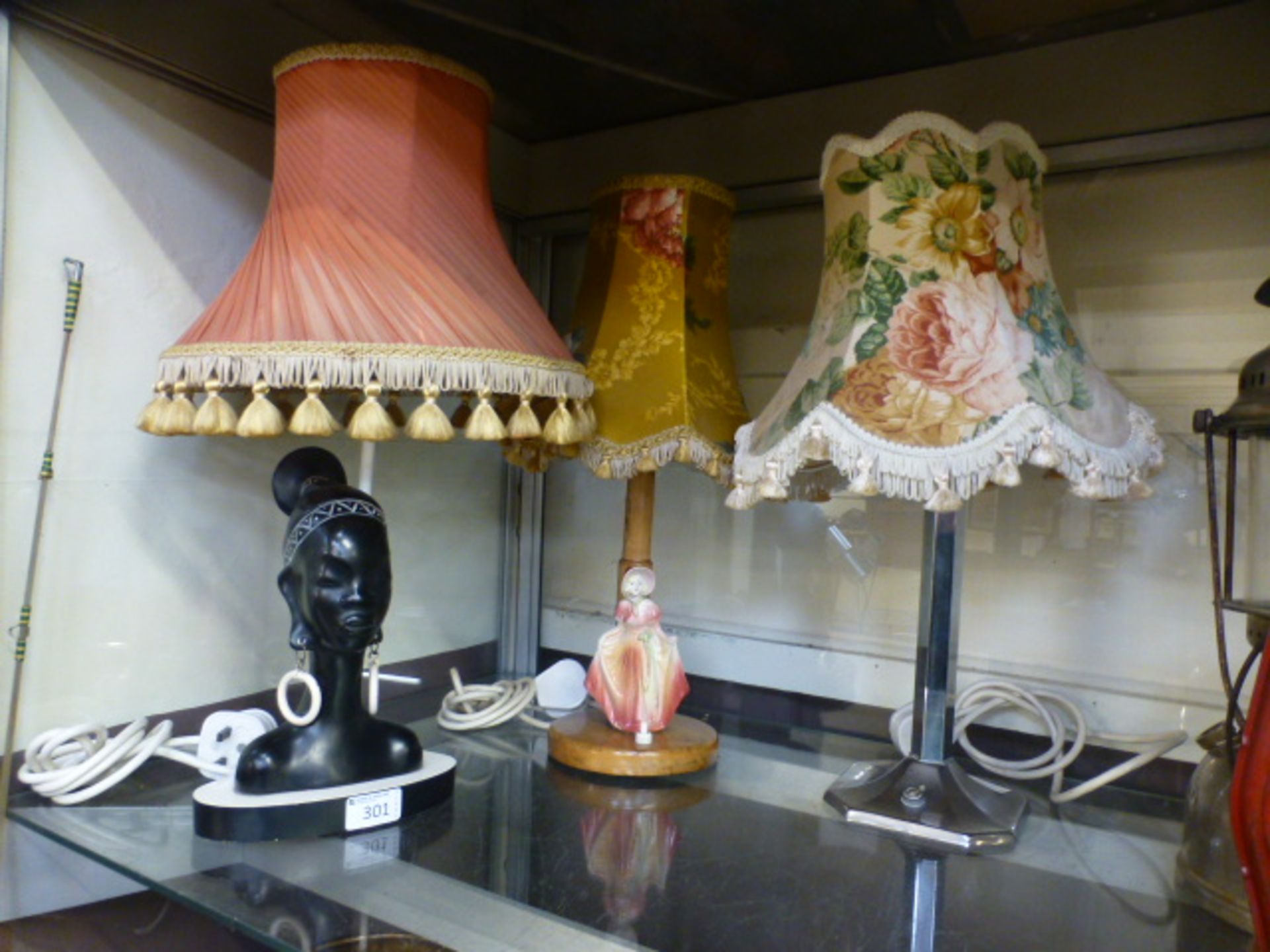 A chrome plated table lamp together with a wooden table lamp with a ceramic figurine and a table