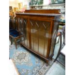 An early 20th century walnut bow fronted glazed display cabinet
