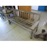 A weathered teak garden bench