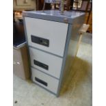 A grey three drawer metal filing cabinet